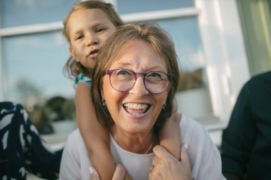 An older woman giving a young child a piggyback ride